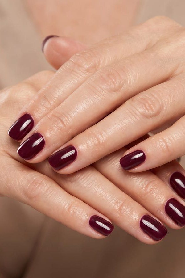Dark Plum on Clasped Hands, elegant winter nail color idea for older women