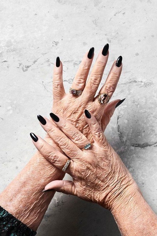 Dramatic Black Almond Nails - dramatic black almond nails with rings, mature hands - elegant nail idea for women over 40