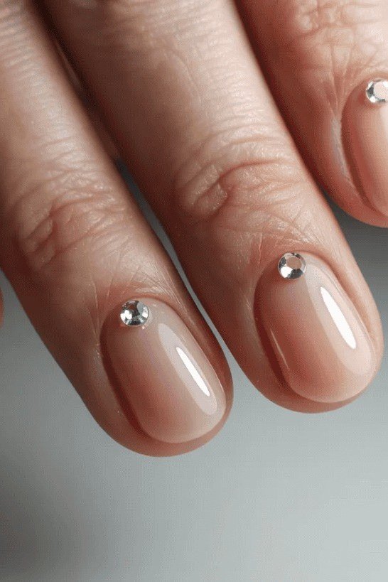 Nude Nails with Crystal Stud Accents - elegant short nail idea for women over 50