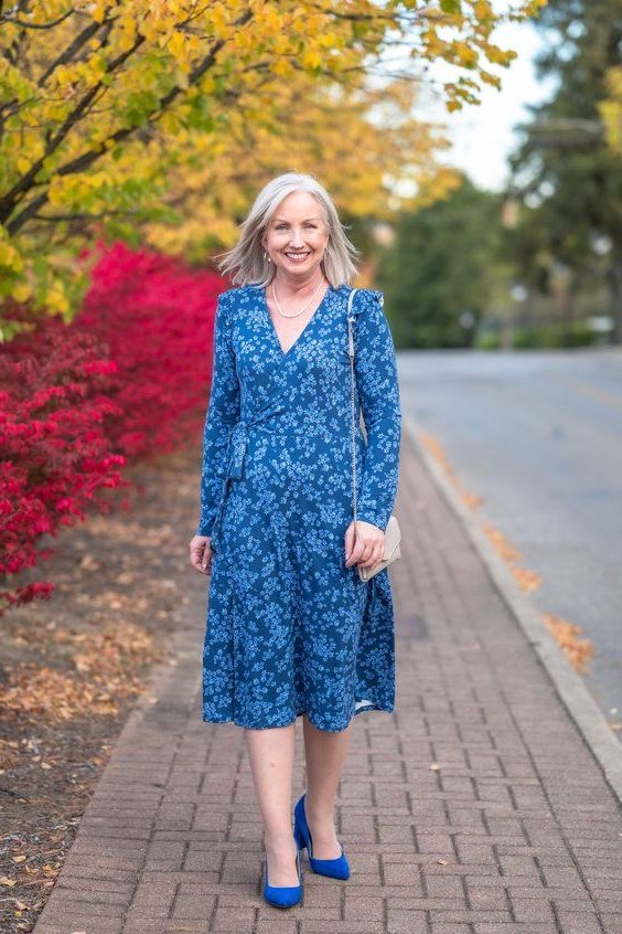 blue floral midi dress with blue heels, older woman on brick path with fall foliage - fall outfit idea for women over 70