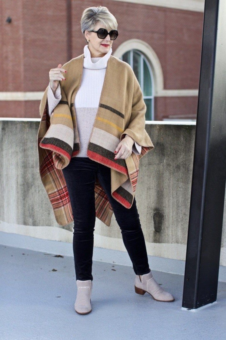 tan plaid fringed cape over white turtleneck with dark jeans and tan ankle boots, older woman - fall outfit idea for women over 70