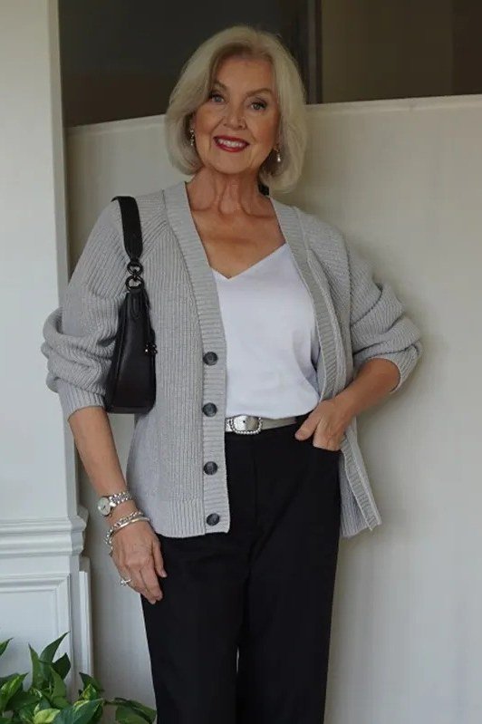 Grey button cardigan over white top, black wide-leg pants, black handbag, full body front view - fall cardigan outfit idea for women over 60