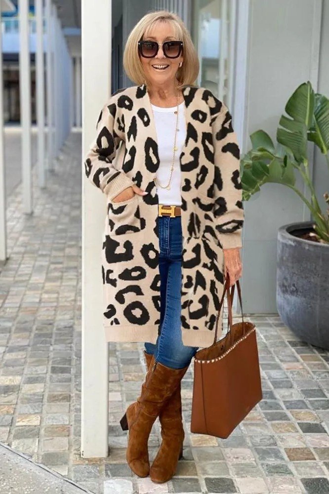 Leopard print long cardigan over white top, blue jeans, brown boots, full body front view - fall cardigan outfit idea for women over 60