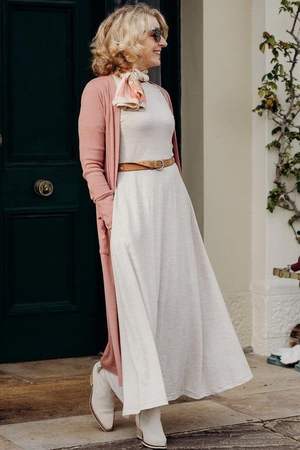 Blush pink cardigan over cream maxi dress with tan belt, 3/4 front view - fall cardigan outfit idea for women over 60