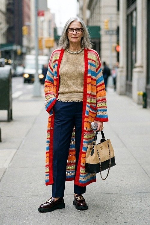 Colorful striped long cardigan over tan top, blue jeans, tote bag, street, full body front view - fall cardigan outfit idea for women over 60