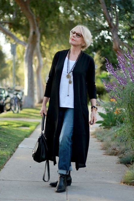 Black long cardigan over white top, blue jeans, street, full body front view - fall cardigan outfit idea for women over 60