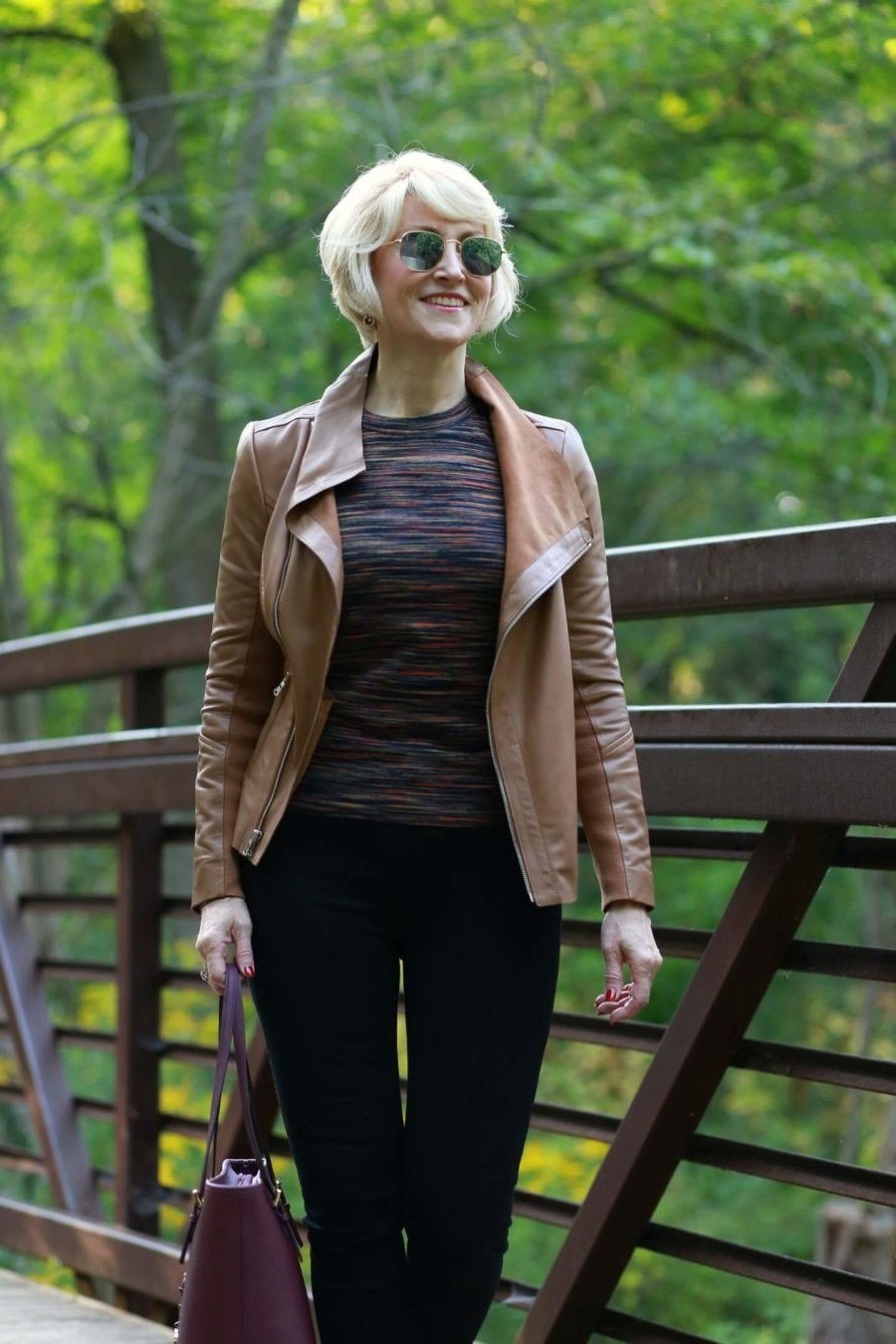 Older woman wearing a tan leather jacket with black trousers