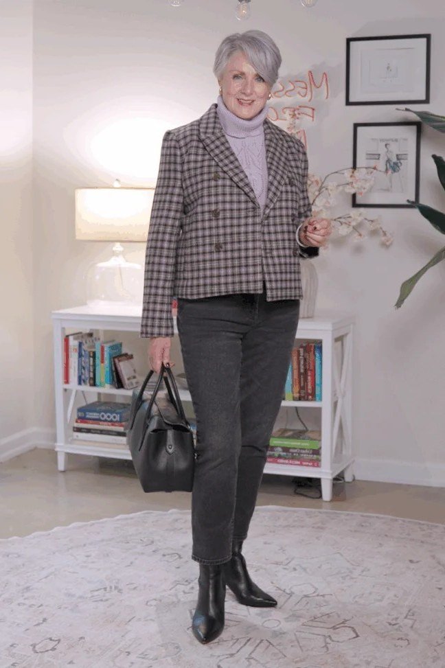 Woman over 60 in a houndstooth blazer with dark jeans