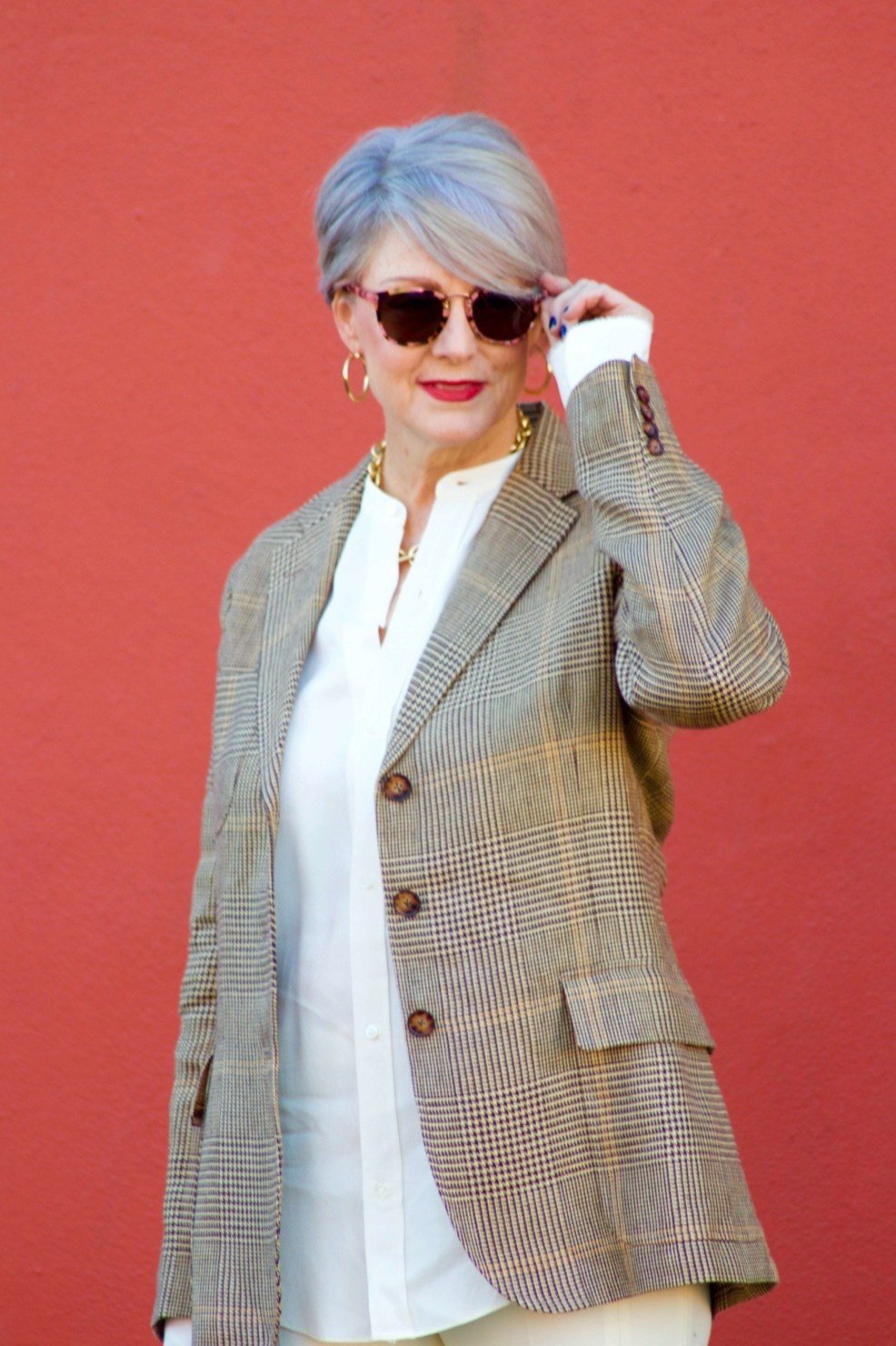 Older woman wearing a tan plaid blazer with a white shirt