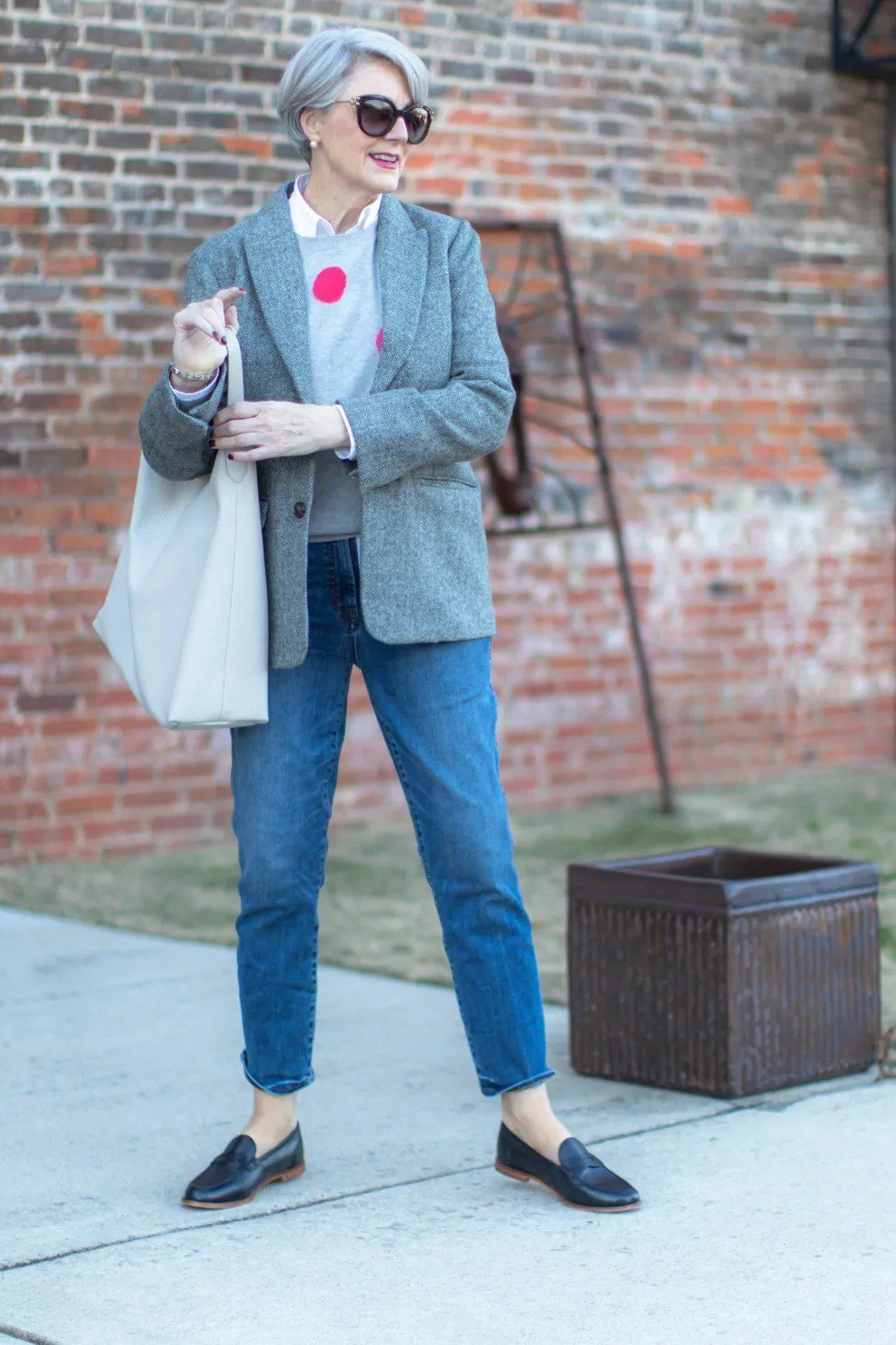 Older woman in a gray blazer with jeans