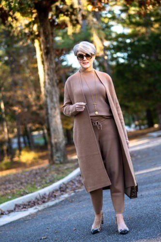Woman over 60 in a taupe long cardigan over a matching knit set