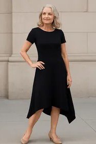 Fall dinner outfit for women over 50: black fit-and-flare knee dress, plain beige wall