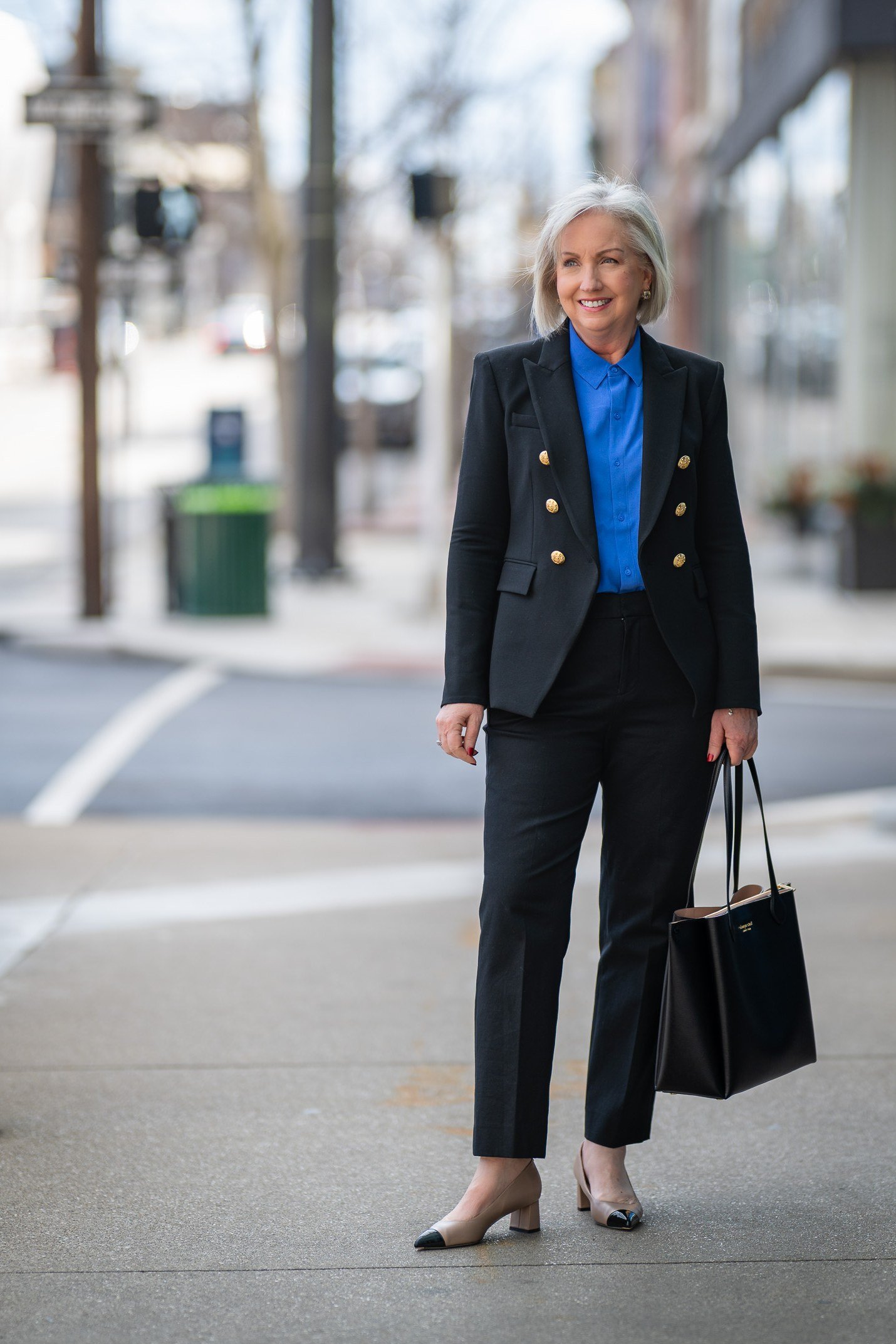 Fall dinner outfit for women over 50: black blazer with cobalt blue top and black trousers, city street