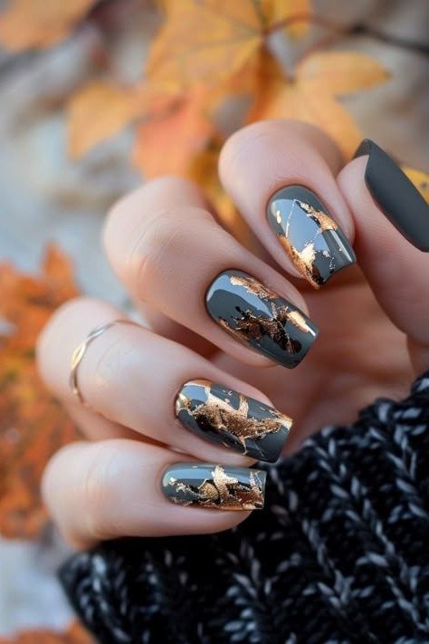 Dark marble nail art with gold veins and fall leaves