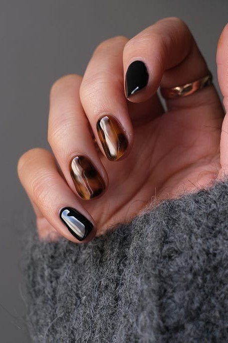 Short dark gray and black nails with a gray sweater