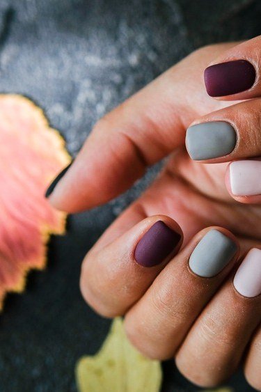 Muted fall nails with a leaf accent on mature hands