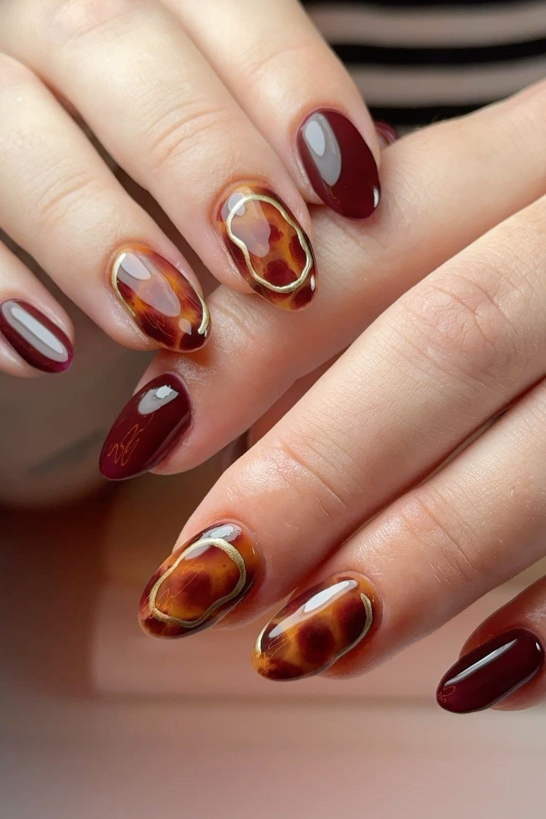 Burgundy short nails with a tortoise accent nail