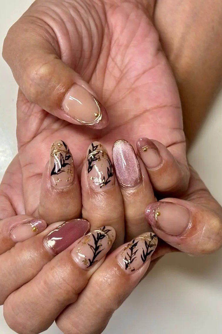 Nude nails with botanical leaf art on mature hands
