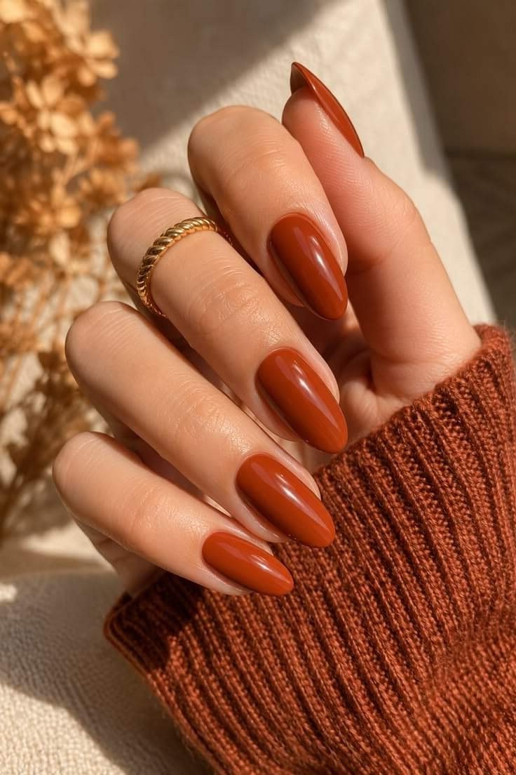 Burnt orange oval nails with a knit sweater