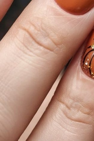 Orange nails with a pumpkin accent nail