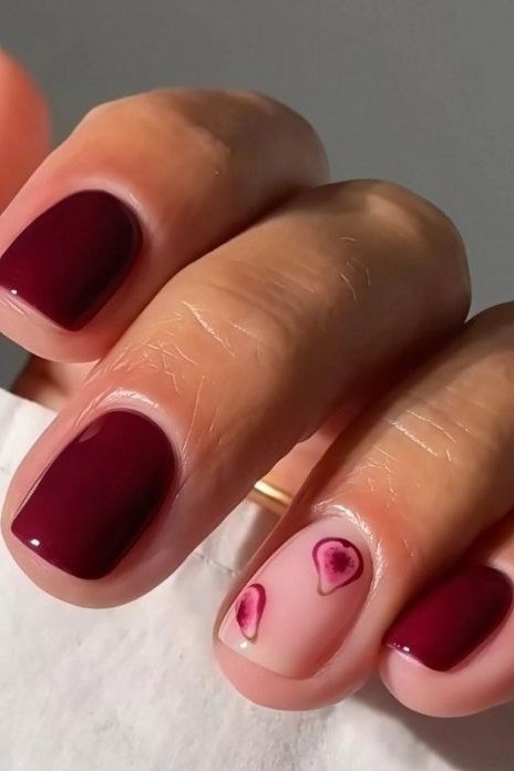 Burgundy nails with a heart accent nail