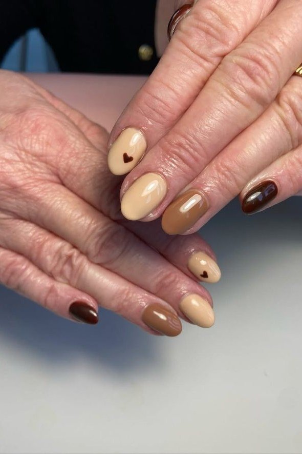 Chocolate and nude two-tone nails on mature hands