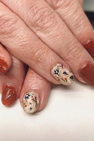 Burnt orange nails with floral accent for women over 60