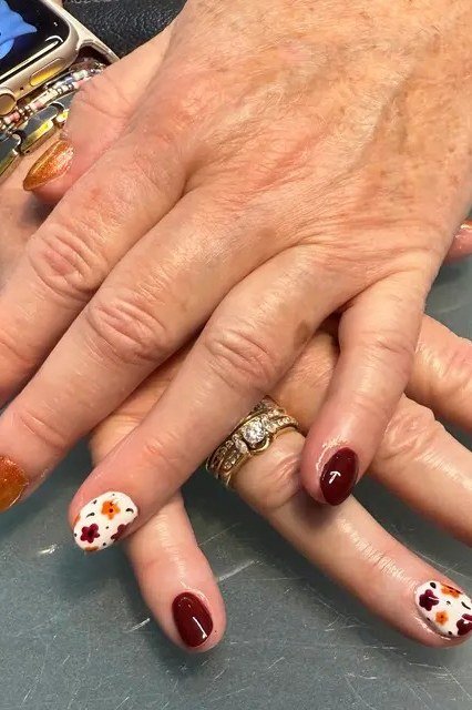 Burgundy and burnt orange nails with fall flower accent art