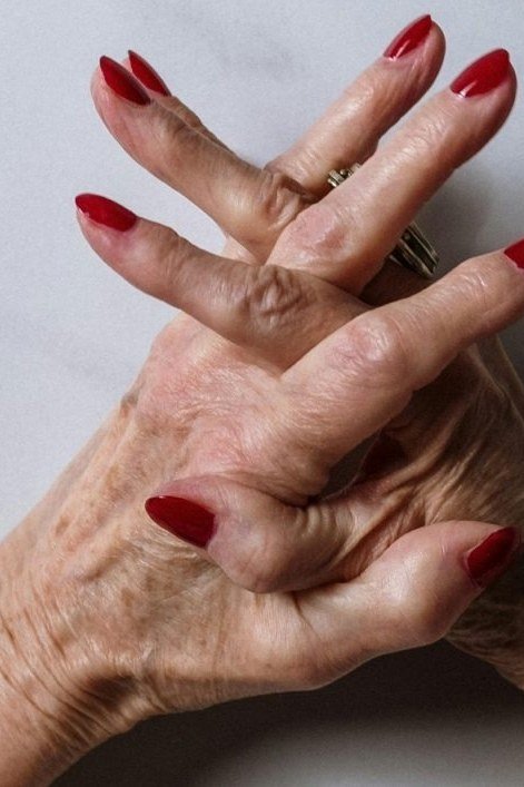 Classic red almond-shaped nails on mature hands