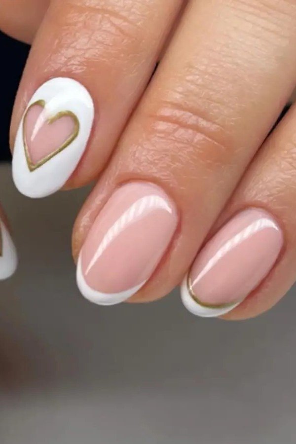 Pink french manicure with gold-outlined heart accent