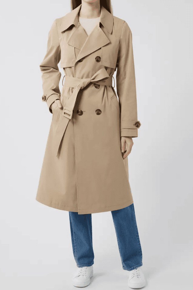 Beige belted trench coat with blue top jeans and white sneakers