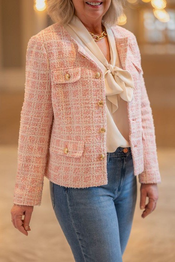 Pink tweed jacket with bow over white top and jeans