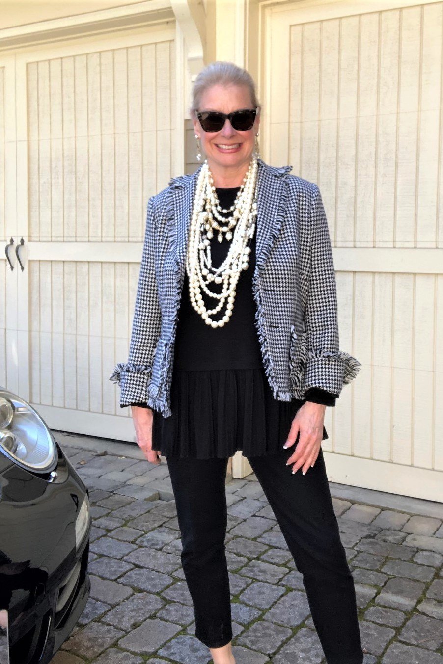 Blue check tweed jacket over black dress with pearls