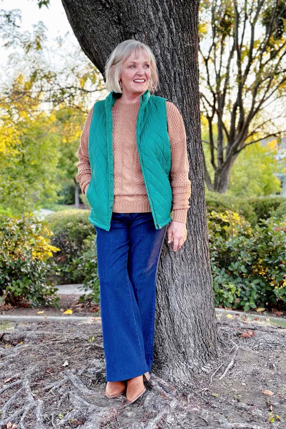 Turquoise quilted vest with blush sweater and blue trousers