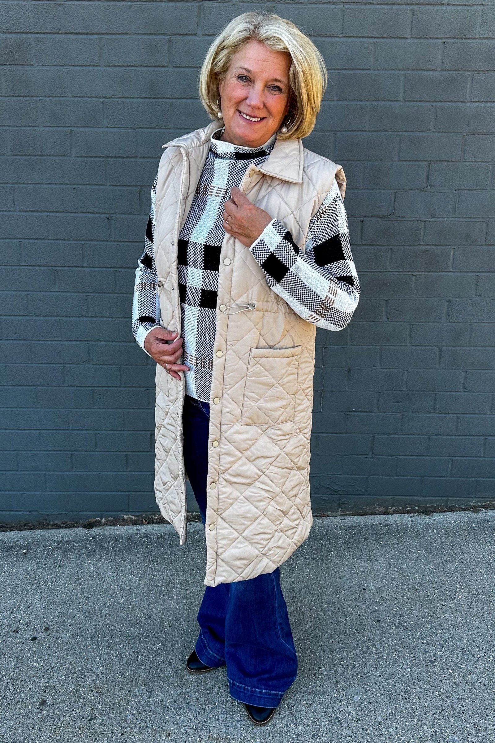 Cream long quilted vest with plaid shirt and jeans