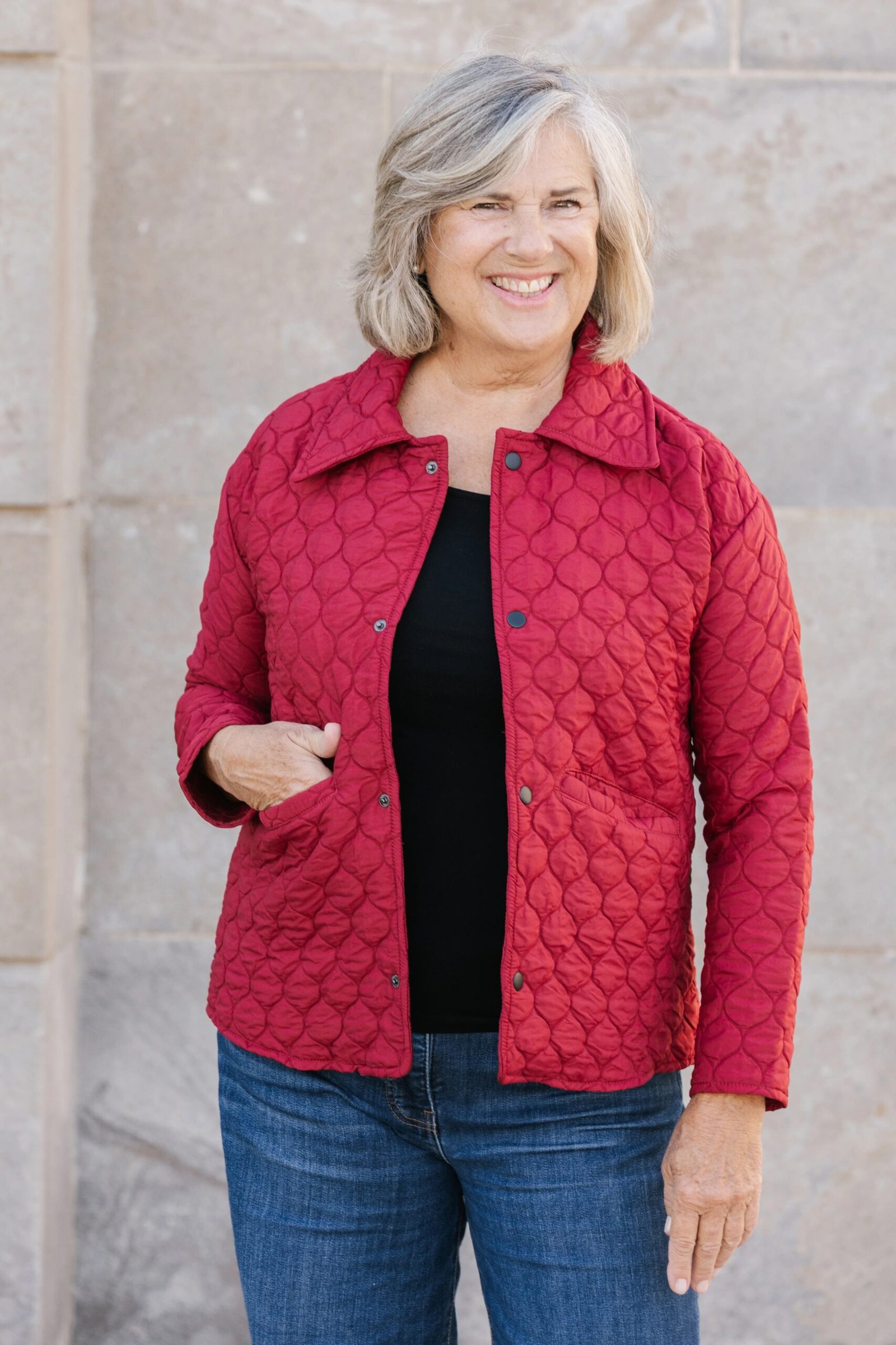 Red quilted jacket with black top and jeans fall outfit