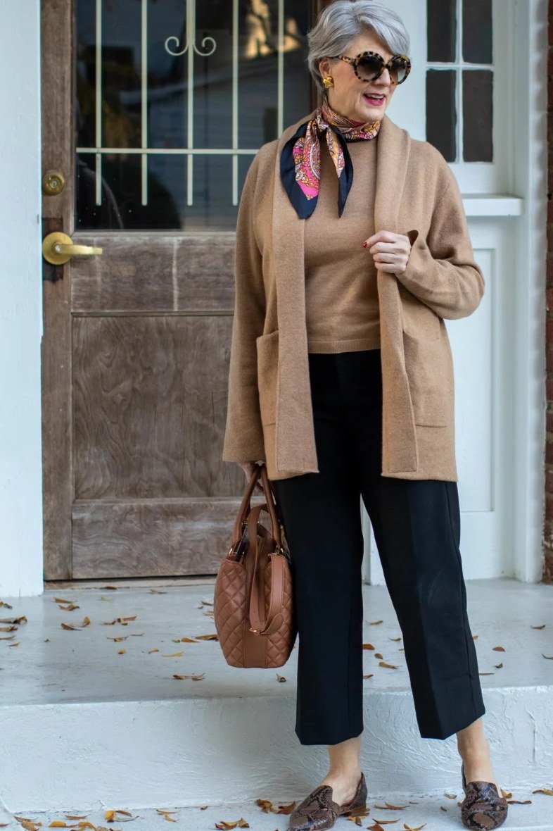 Camel cardigan with scarf over black top and cropped pants