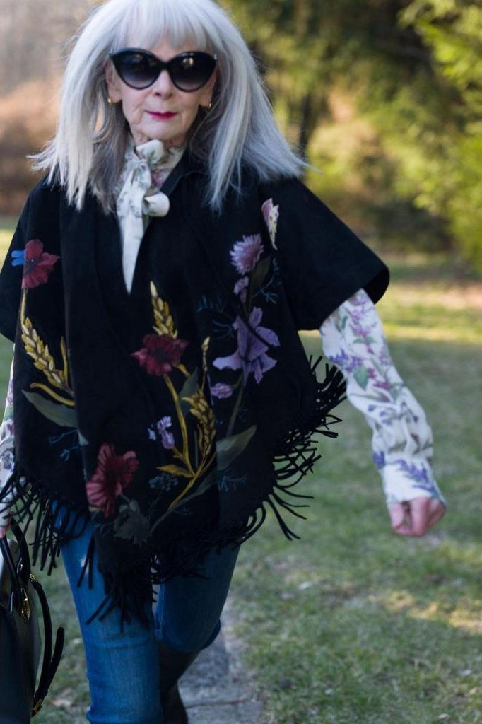 Black embroidered floral poncho with fringe and jeans