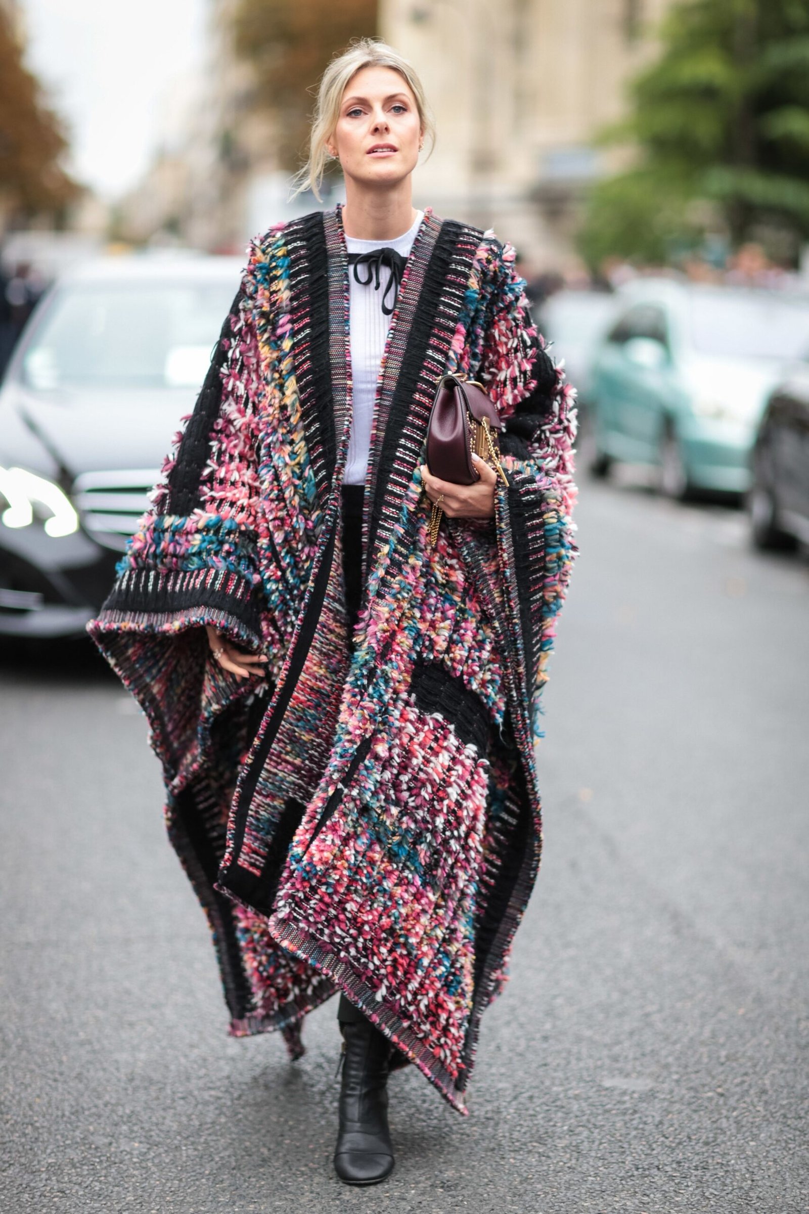 Colorful knit poncho with dark top and boots street style