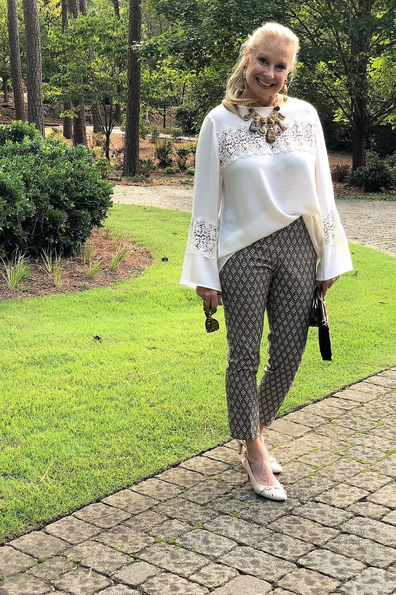 white lace-trim blouse with patterned trousers, fall work outfit for women over 50