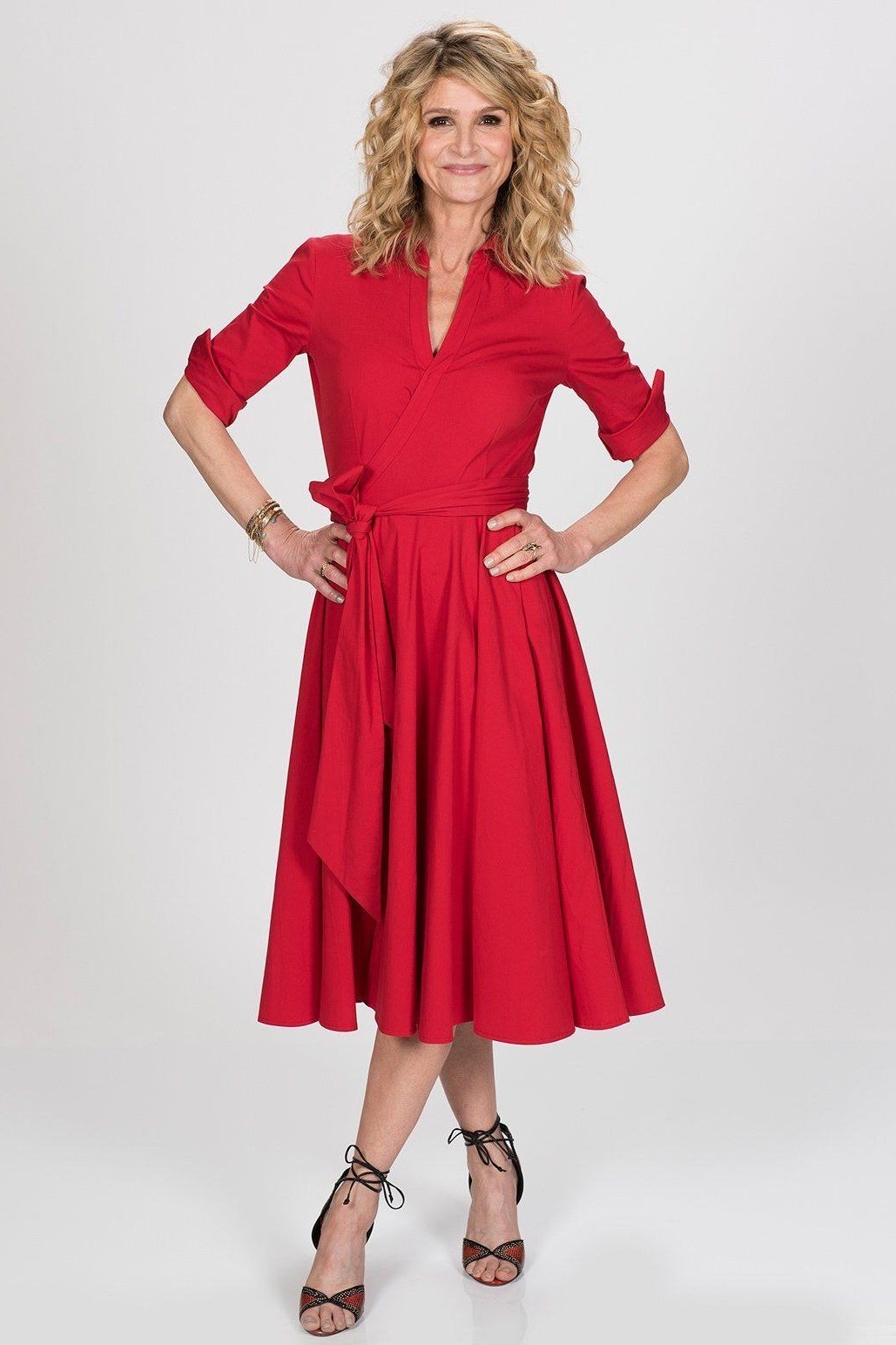 Red wrap fit-and-flare midi dress for women over 50 with three-quarter sleeves on blonde older woman