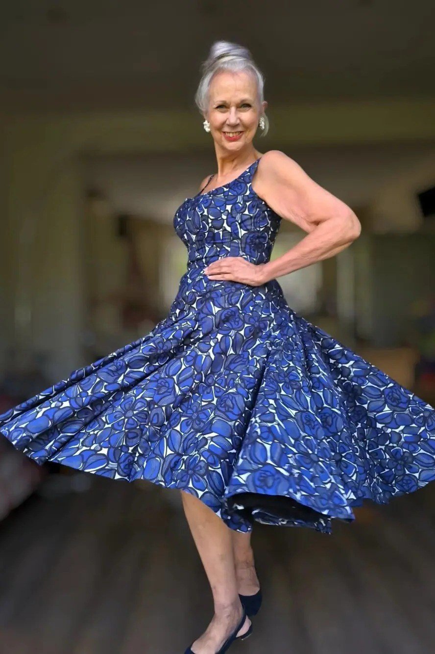 Blue floral twirl fit-and-flare dress for older women, grey-haired woman spinning