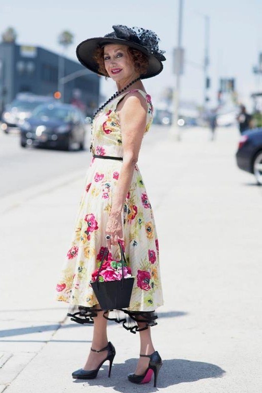 Yellow floral fit-and-flare midi dress with wide-brim hat for women over 60 on sunny street