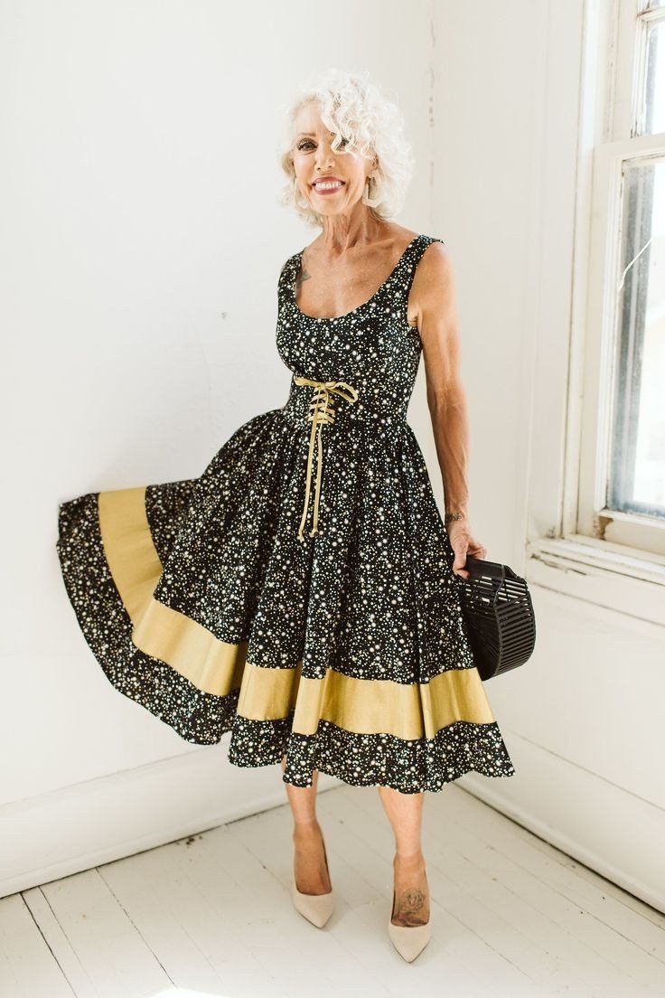 Black floral fit-and-flare dress with gold hem band for grey-haired woman