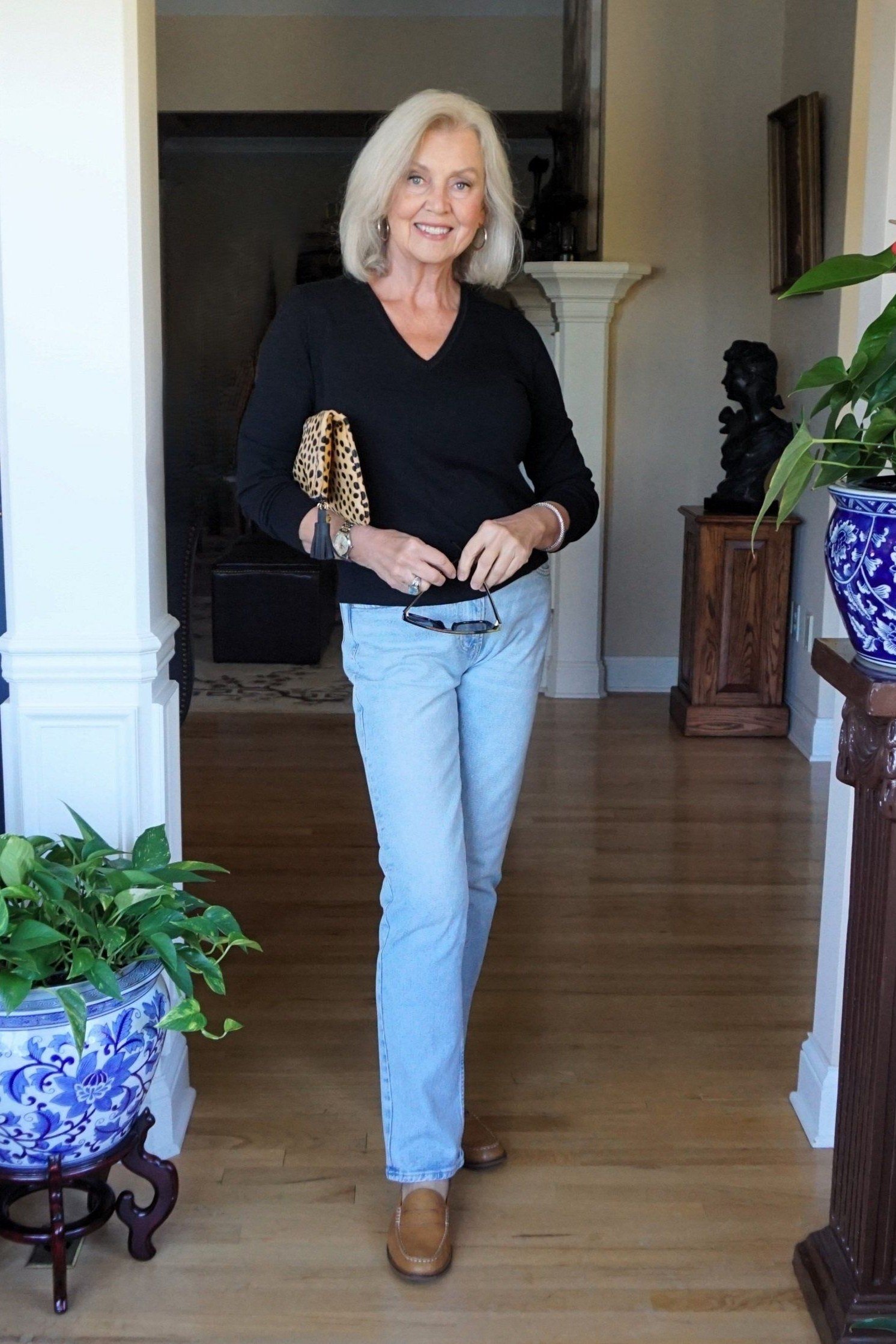 A soft black V-neck sweater with light-wash straight jeans is relaxed and pretty. Tan ankle boots warm the palette, and a leopard clutch adds a playful pop. The V-neckline opens the neck and shows a little skin. Great for date night or dinner with friends.