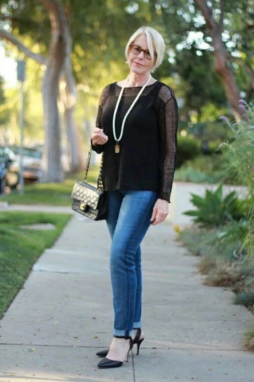 A black top with sheer sleeves adds evening glamour to medium skinny jeans. A long necklace, black heels, and a quilted bag dress it up. The sheer sleeves show just enough skin to feel special. Wear it to dinner, a show, or any night you want to shine.