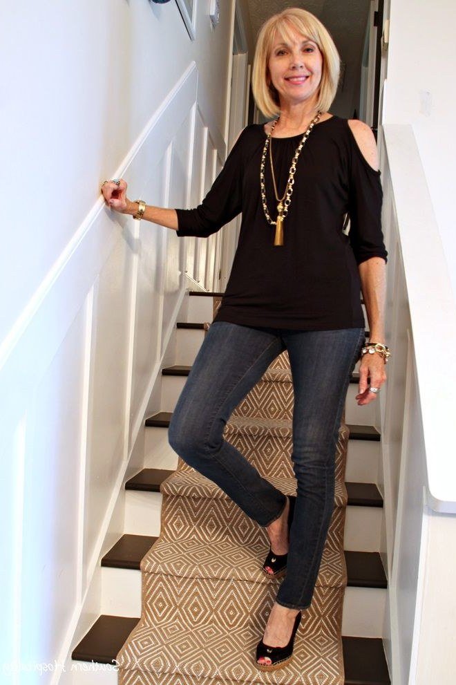 A black cold-shoulder top brings subtle drama to dark skinny jeans. A long necklace and black heels make it evening-ready. The shoulder cutouts show a flattering flash of skin. A fun choice for a night out or holiday party.