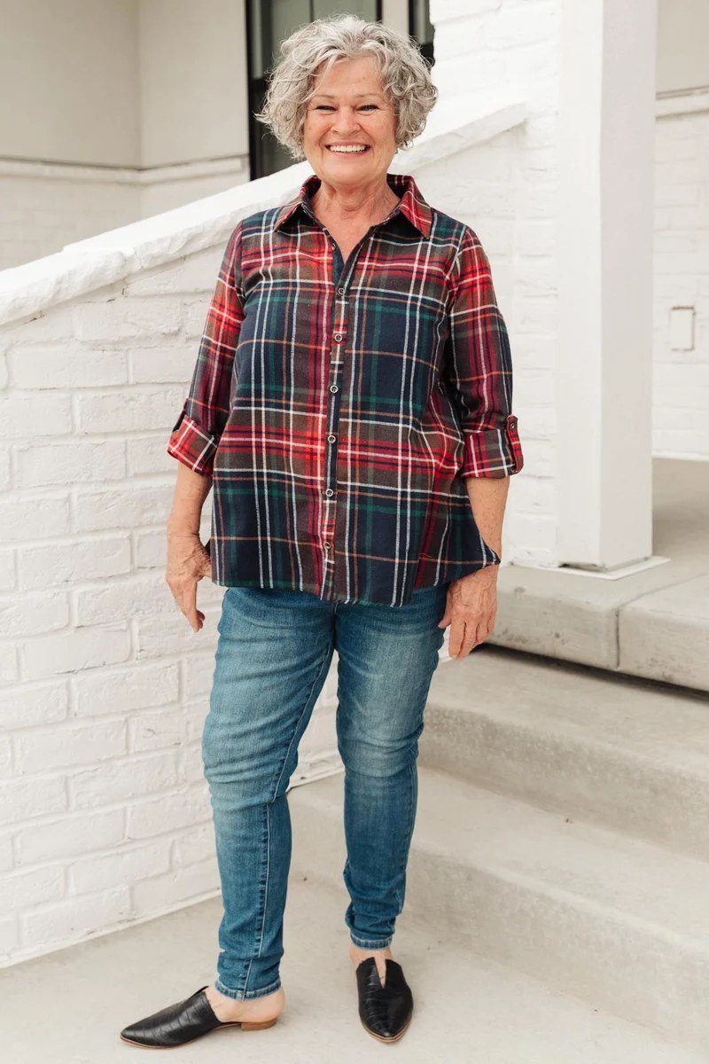 A red-and-black plaid shirt with medium jeans and black flats is bold fall style. The red plaid is the undeniable star. Curly gray hair looks fantastic with strong colors. Perfect for fall festivals or football weekends.