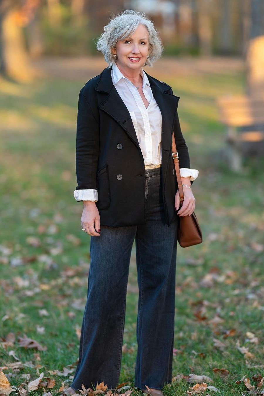 A black blazer over a crisp white shirt with dark wide-leg jeans is powerful and polished. A brown leather bag adds warmth. The high contrast of black and white always looks sharp. Wear it to meetings, dinners, or anywhere you want to feel strong.