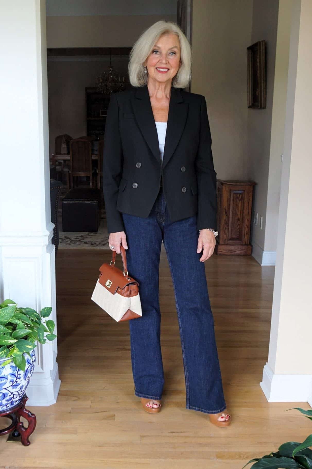 A black blazer over a white top with dark wide-leg jeans is modern power dressing. The high contrast is bold and graphic. A striking look for creative offices or evenings out.